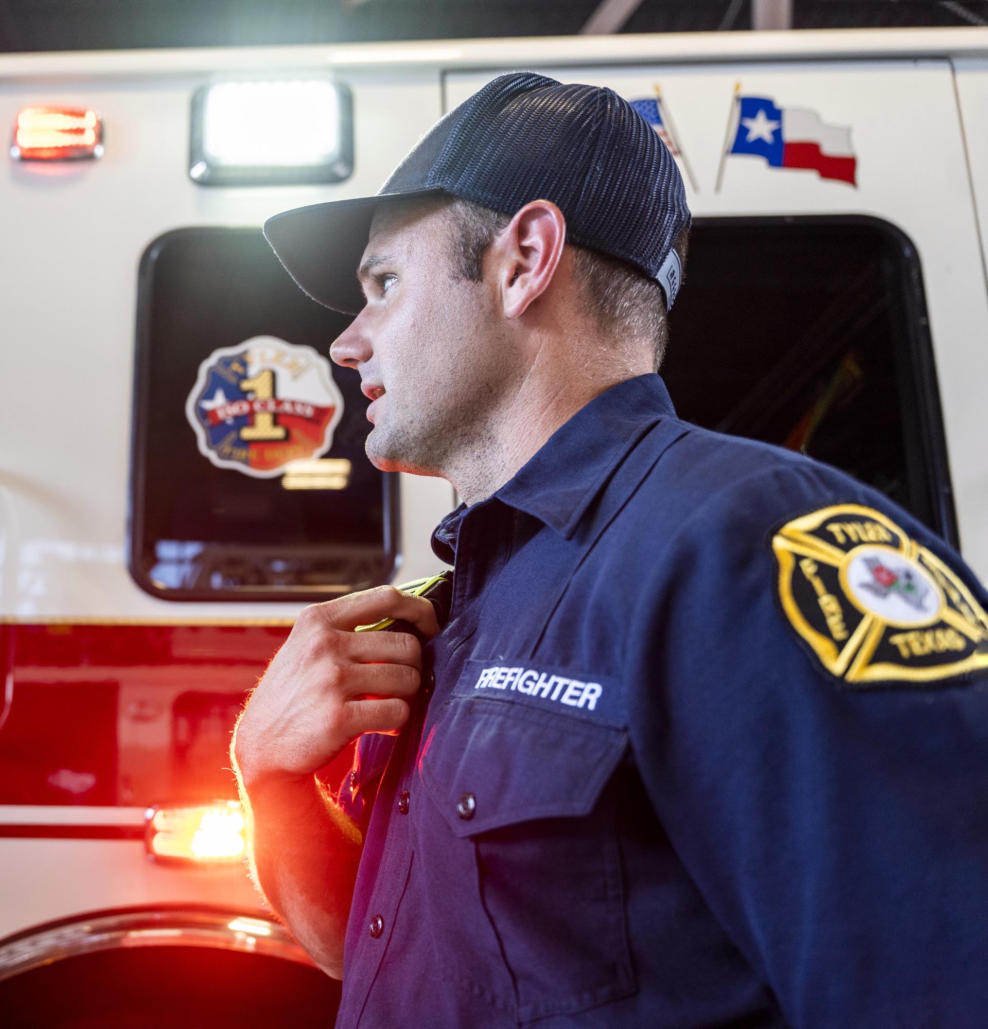 Firefighter with radio and engine in background