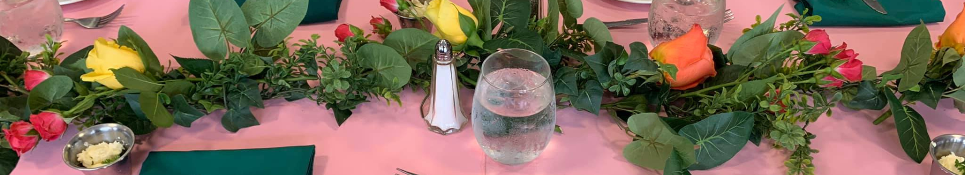 Pink tablescape with roses and fancy place settings at the Tyler Rose Garden Center